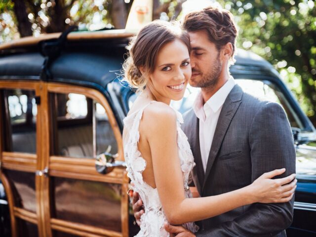 Photo of bride and groom standing beside Sunshine Coast Wedding Classic Car Hire Woody